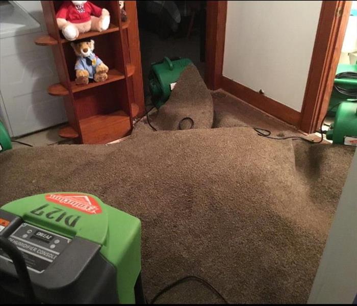 Our green drying equipment set up and running under a carpet in a bedroom that had suffered from water damage.